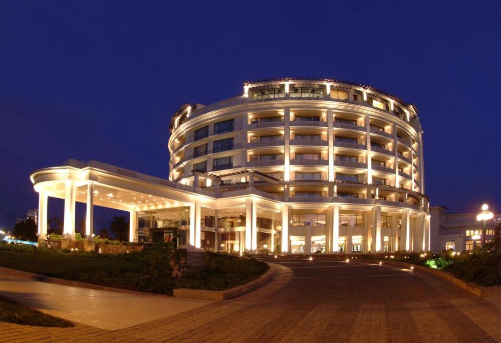 Edifício circular iluminado à noite, com colunata na entrada